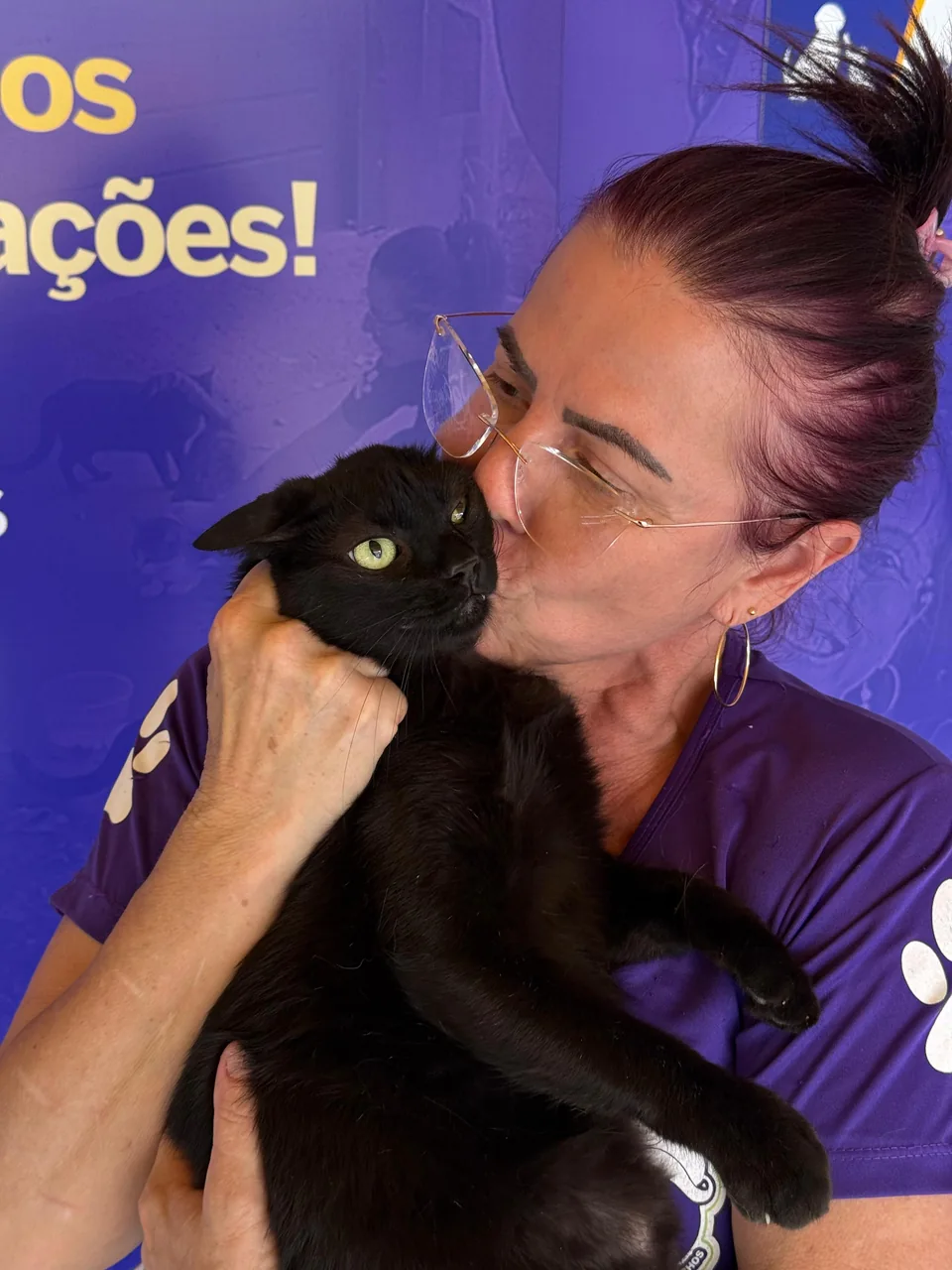 Diane com um gato preto no colo, na Associação Vitória dos Bichos.