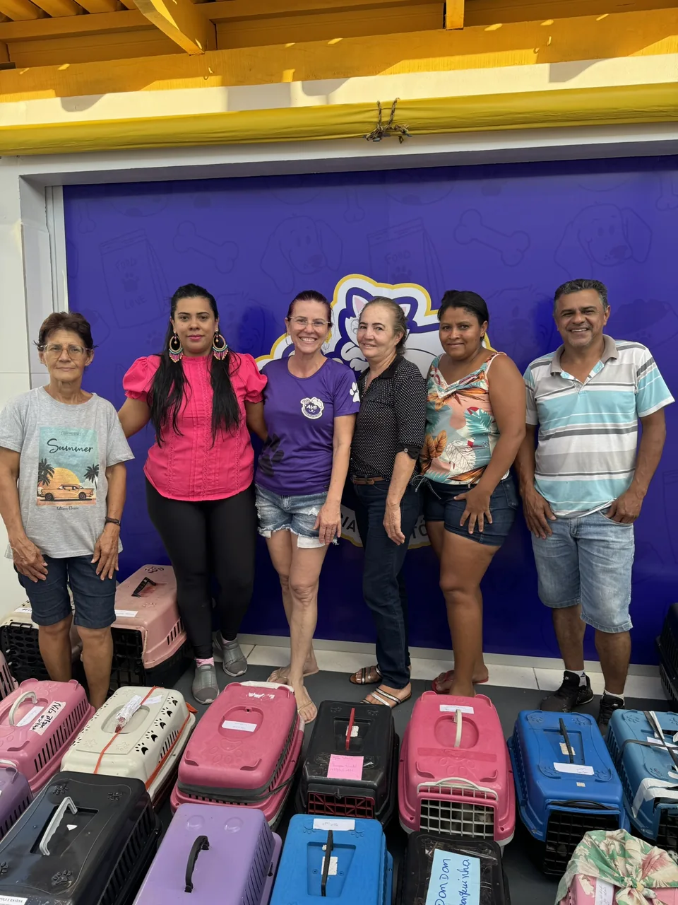 Equipe reunida na Associação Vitória dos Bichos, com caixas de transporte de animais.
